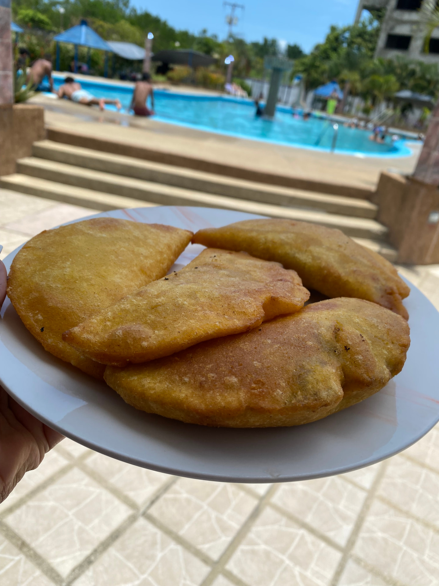 Empanadas recién hechas servidas junto a la piscina